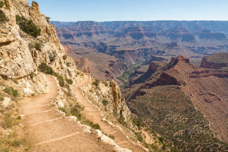 A steep switchback trail descending through Grand Canyon rock layers