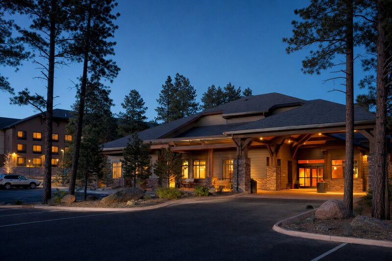 A high-desert gateway hotel among ponderosa pines at dusk