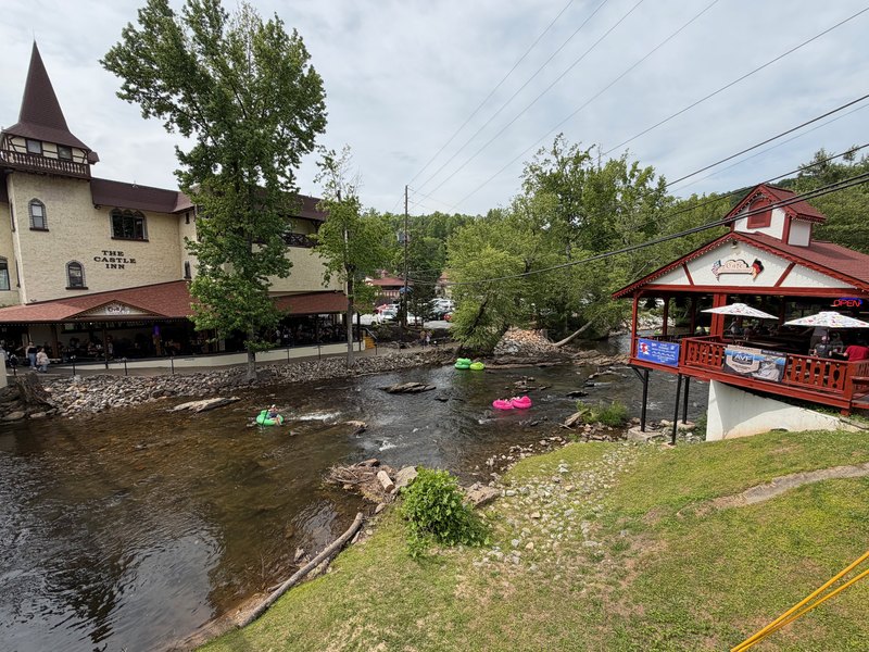 Tubers floating past riverfront buildings in Helen Georgia