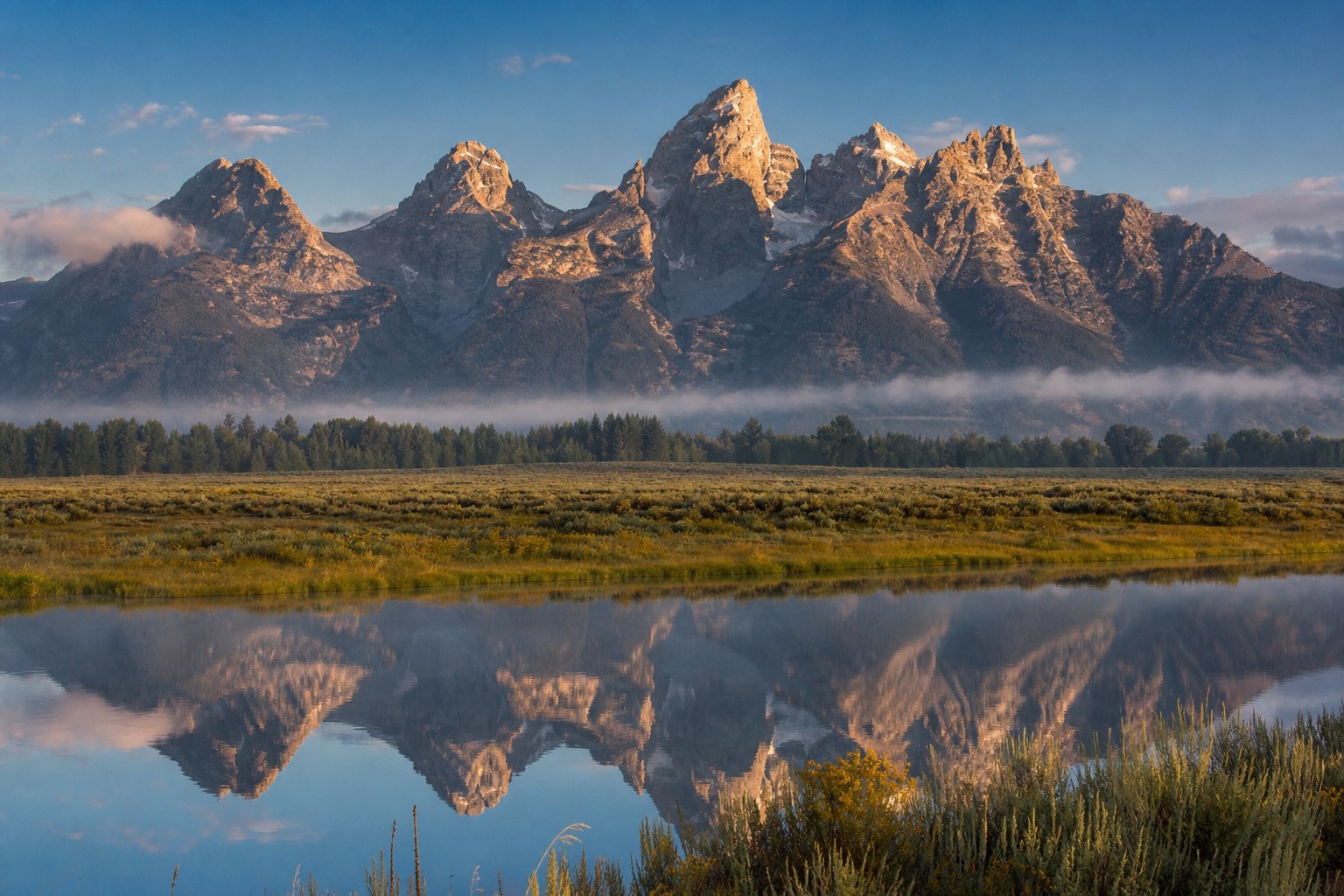 Teton peaks reflected in calm water at Grand Teton National Park