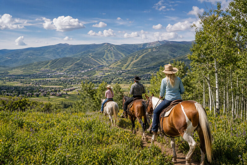 Horseback riding through meadow mountains Steamboat Springs Colorado summer