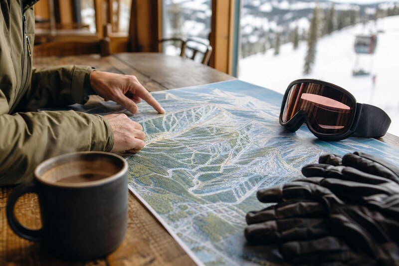 Hands planning a Winter Park ski day with a trail map