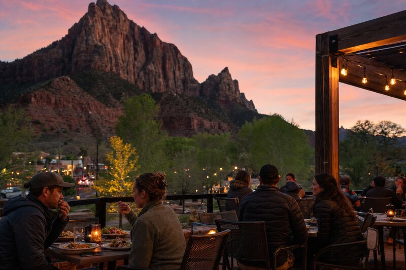 Contextual illustration of an outdoor dinner in Springdale beneath sandstone cliffs